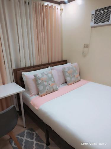 LocsinCasita de Reina Staycation House - A cozy 1-Bedroom condo-style house的卧室配有带枕头的床铺和窗户。