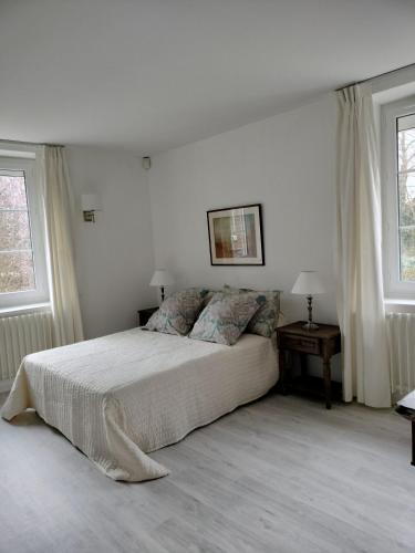 奥利韦Les Mulotières的一间白色卧室,配有床和2个窗户
