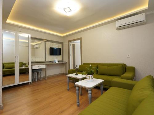伊斯坦布尔gazelle suites的一间带绿色沙发的客厅和一间厨房