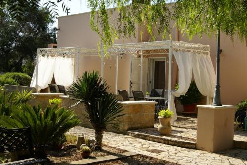 阿莱齐奥泰努塔阿拉特住宿加早餐旅馆的房屋设有白色窗帘的庭院