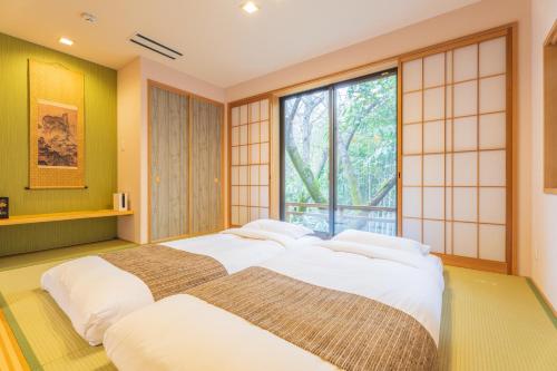 Izumi樱泉会馆的一间卧室设有一张大床和一个窗户。
