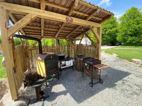 IzvoareHoliday Nature House的一个带炉灶和烧烤架的木制凉亭