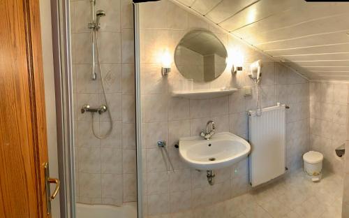 圣卡尼兹Pension Miklautz的带淋浴、盥洗盆和镜子的浴室