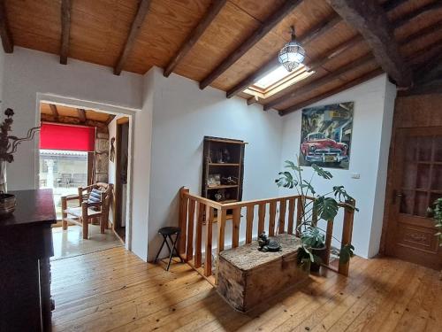 RubiacósLa Casa de las rocas - Ribeira Sacra的客厅铺有木地板,设有楼梯。