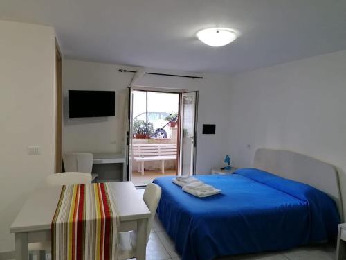 福尔米亚Gianola Residence Formia的一间卧室配有一张蓝色的床和一张桌子