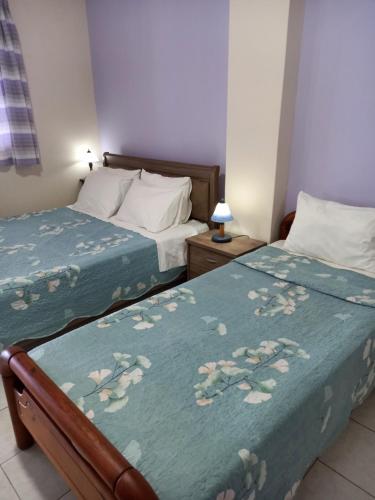 AkhladheríKorasida Blue Coast的一间卧室配有两张床,带鲜花的蓝色毯子