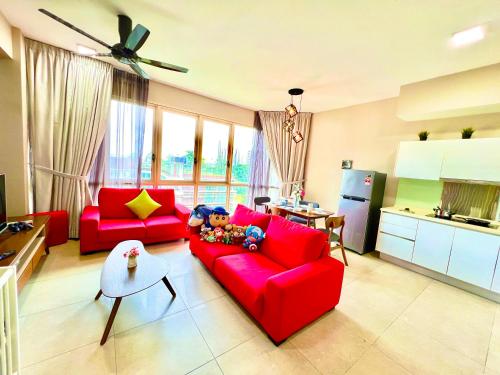 努沙再也Legoland-3min Walk-HappyDream Suite at Afiniti -8pax-Cozy,Comfy&Convenience 2BR with Bathub的一间带红色沙发的客厅和一间厨房