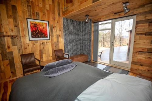劳加尔瓦特恩Gljásteinn by Golden Circle的卧室配有一张床铺,位于带木墙的房间内
