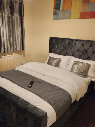 KentCaptivating 3-Bed House in Kent的卧室内的一张大床和黑色床头板