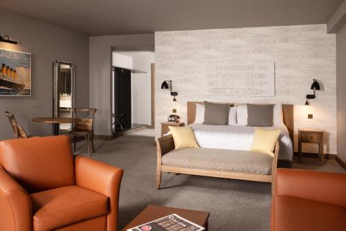 利物浦利物浦泰坦尼克酒店的一间卧室配有一张床、一张沙发和一把椅子