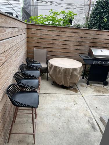费城Luxury Hot Tub Four Seasons的庭院设有四把椅子、一张桌子和烤架