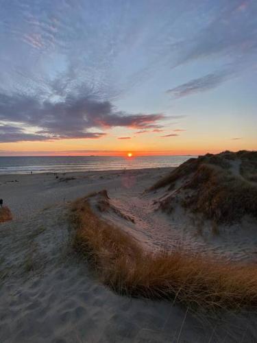KleppBorestranda - Nytt strandhus med 6 sengeplasser!的海滩上的日落,背景是大海