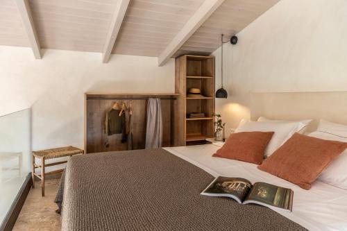 瓦西里科斯Montesea - Luxury Nature Villas的一间卧室配有一张床,上面有一本书