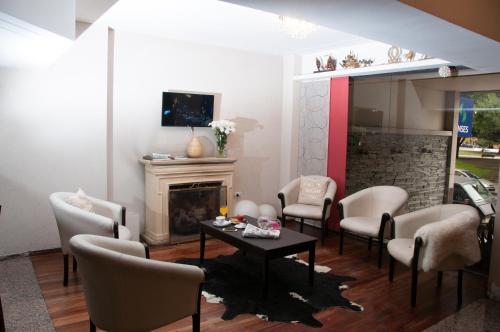 拉普拉塔Hotel del Rey的客厅配有椅子、桌子和壁炉