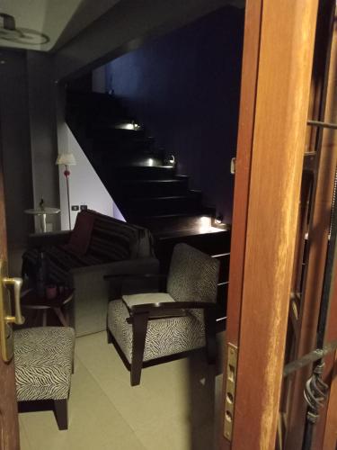 特尔马斯德里奥翁多Infinit Home Duplex entero的客房设有带椅子和沙发的楼梯。