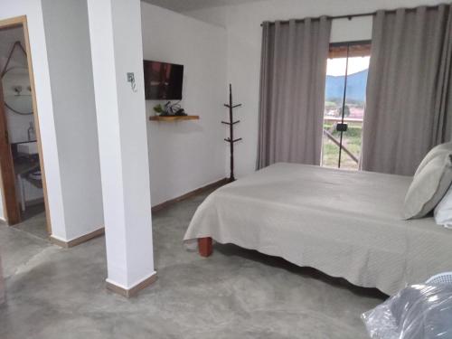 圣托梅-达斯莱特拉斯Chales Paraíso STL的卧室配有白色的床和窗户。