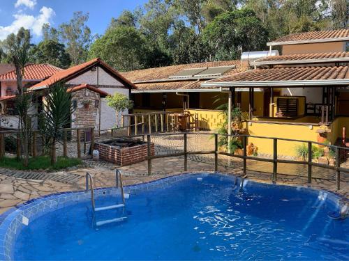 马卡科斯Pousada Casinha Velha的房屋前有游泳池的房子