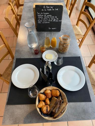 屈屈尼昂奥贝尔格拉塔博乐都库乐酒店的餐桌,盘子和一篮面包