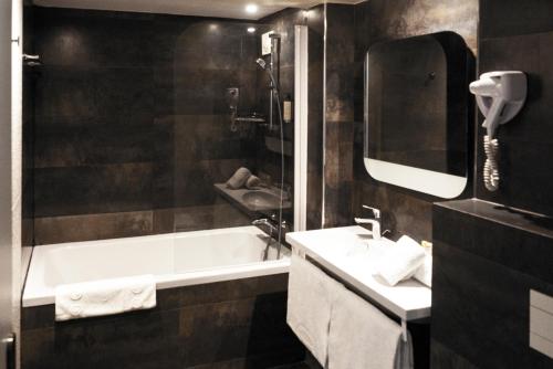 巴黎贝斯维斯特阿尔格鲁内申酒店的带浴缸、水槽和镜子的浴室