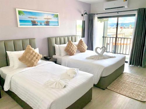 合艾Remas Hotel Hatyai的酒店客房设有两张床和一个阳台。