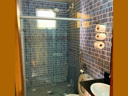马卡科斯Pousada Casinha Velha的蓝色瓷砖浴室设有水槽和卫生间