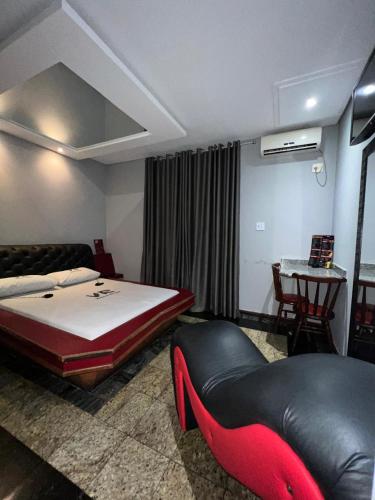 圣维森特岛Motel Vitoria Reggia的一间卧室配有一张床、一张沙发和一张桌子