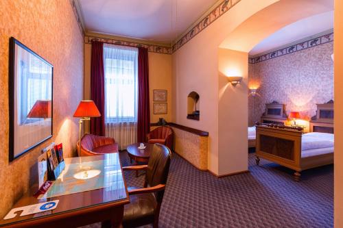 比尔森欧陆酒店的酒店客房设有一间带书桌和床的卧室