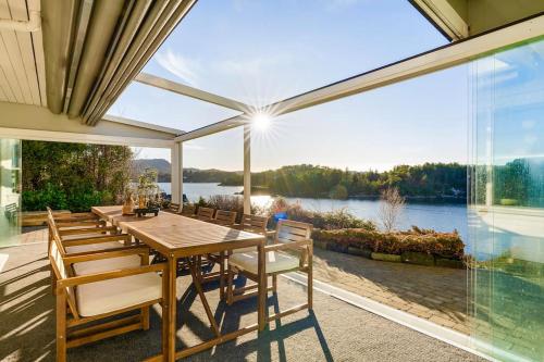 FoldnesWaterfront Villa w/Boat&kayaks. 15min from Bergen的一间带桌椅和大窗户的用餐室