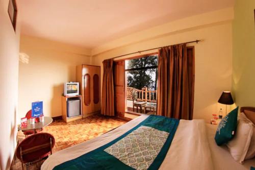 西姆拉Goroomgo Kalra Regency - Best Hotel Near Mall Road with Parking Facilities - Luxury Room Mountain View的酒店客房设有一张床和一个阳台。