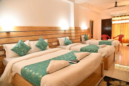 布莱尔港Hotel Sea Rock Porte Blair的绿色和白色的客房内的三张床