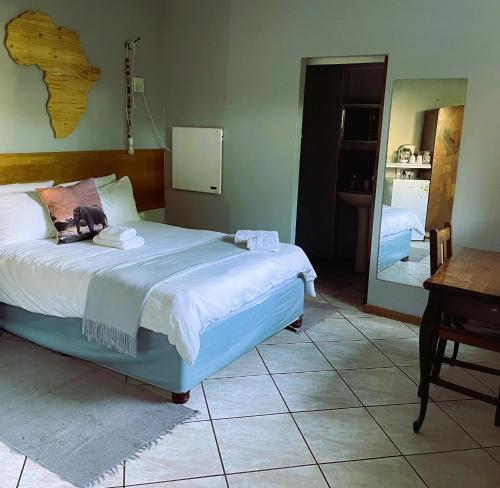 博克斯堡Celtis Lane Guest House的一间卧室配有一张床、一张桌子和一面镜子