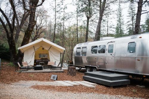 三河城AutoCamp Sequoia的帐篷和拖车停在树林里