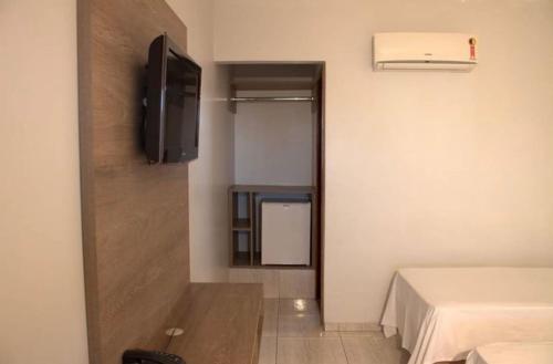 阿拉瓜伊纳Hotel Ipanema的小房间设有电视和床