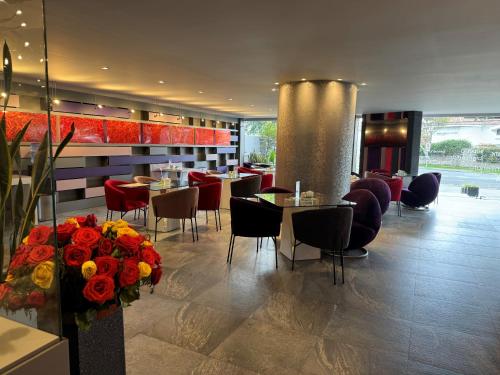 昆卡利奥尼精品酒店的一间带桌椅和鲜花的餐厅