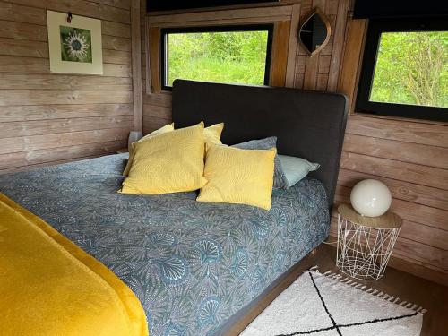普罗旺斯艾克斯Chalet bois cosy avec piscine Aix nature的小房间一张带黄色枕头的床
