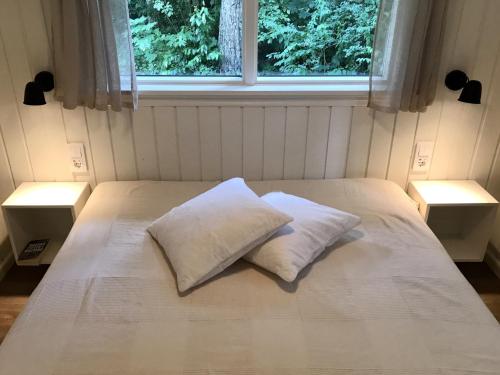 SjöboNordic Relax House - Stonehouse的一张带两个枕头的床和窗户