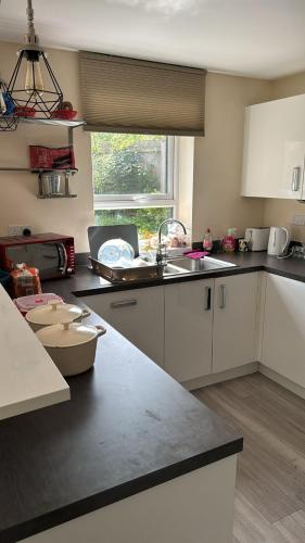 特尔福德Telford Guest House 1的厨房配有白色橱柜、水槽和窗户。
