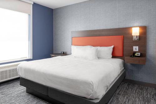 诺斯维尔Home2 Suites By Hilton Northville Detroit的一间卧室配有一张带橙色床头板的大床