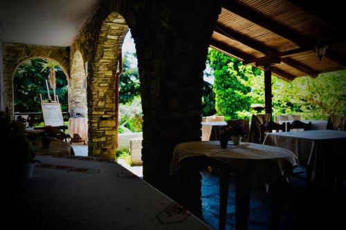 欧拉努波利斯Hotel Paradise Ouranoupolis的一间设有两张桌子的房间和一座石头建筑