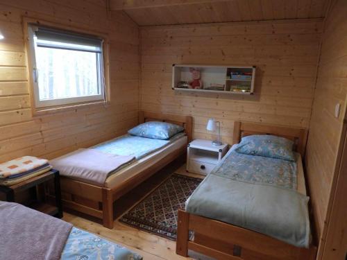 兹维日涅茨DOMKI , Pokoje gościnne Ustronie的小木屋内带两张床的房间
