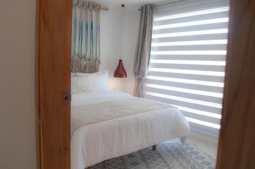 El RoqueSabbia By LD Hoteles的卧室配有白色的床和窗户。