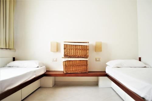 罗萨岛Rocciarossa的一间设有两张床和一张带篮子的桌子的房间