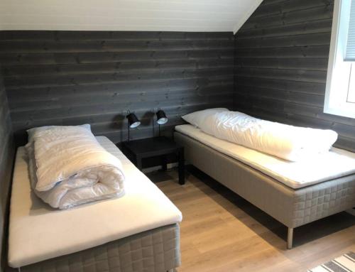 BergsetCabin - Målselv fjellandsby的一张黑墙客房内的两张床