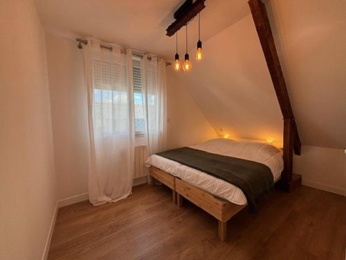 普洛埃默Les Chênes en duplex的一间卧室设有一张床和一个窗口
