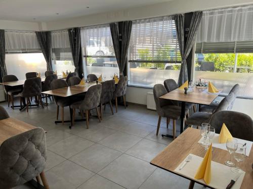 弗勒里耶Hotel Restaurant du Moulin的餐厅设有木桌、椅子和窗户。
