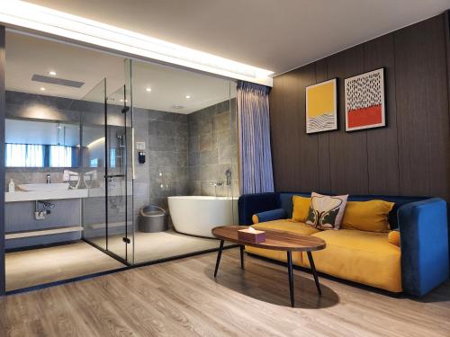 花莲市花蓮品悅文旅Hualien Pink Corner Hotel的带沙发的客厅和浴室。