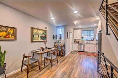 费城Modern South Philly Townhome的一间带桌椅的客厅和一间厨房