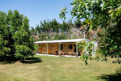 WaiparaSelf contained & self serviced Farmstay in Waipara wine region, bath & fire的树木林地的小木屋