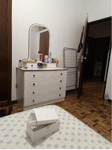 维塞乌Quarto pernoitar viseu的客房内的白色梳妆台和镜子