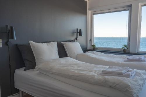 努克The Black House Tuapannguit 48的卧室设有白色床,享有海景